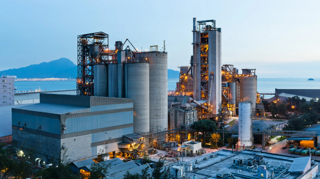 Planta industrial iluminada ao anoitecer